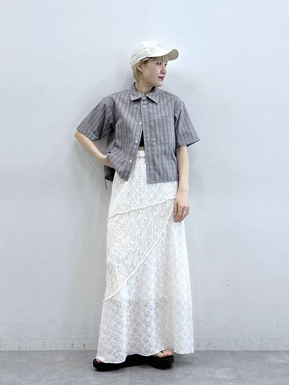 グレー系のシャツ/ブラウス、ホワイト系のスカート、ブラック系のサンダルを着用したレディースの春コーディネートの3枚目の写真