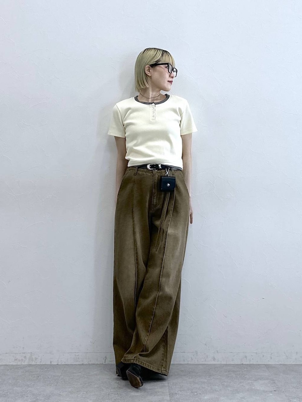 ブラウン系のデニムパンツ、ホワイト系のTシャツ/カットソー、ブラック系のベルトを着用したレディースの夏コーディネートの2枚目の写真