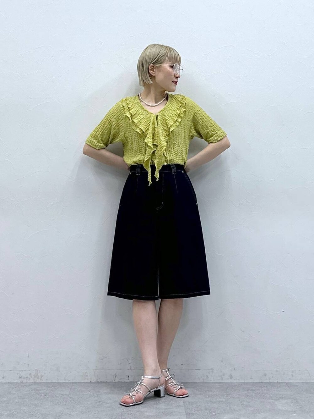 イエロー系のシャツ/ブラウス、ブルー系のデニムパンツ、ブラック系のメガネを着用したレディースの夏コーディネートの4枚目の写真