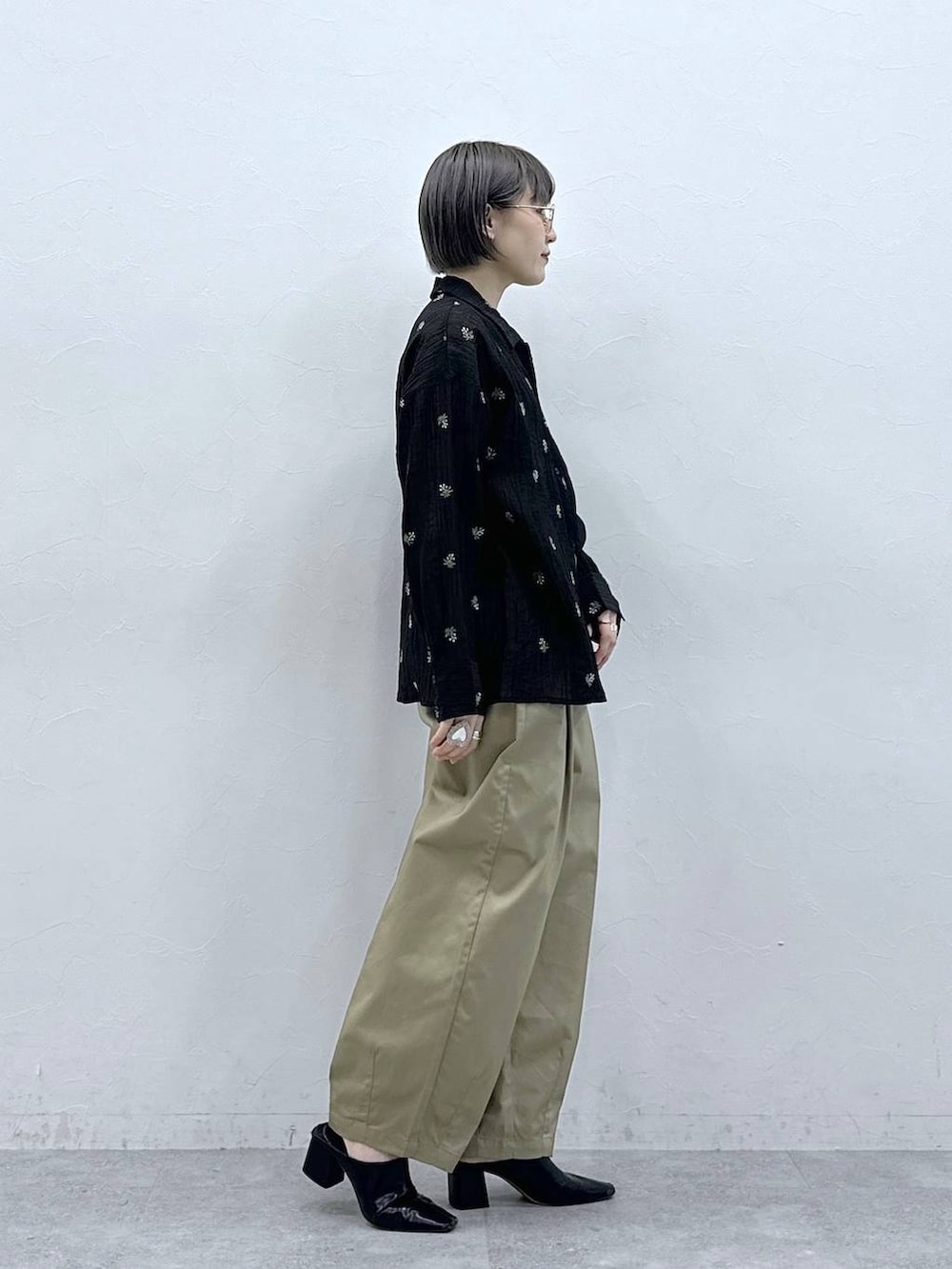 ベージュ系のチノパンツ、ブラック系のシャツ/ブラウスを着用したレディースの春コーディネートの4枚目の写真