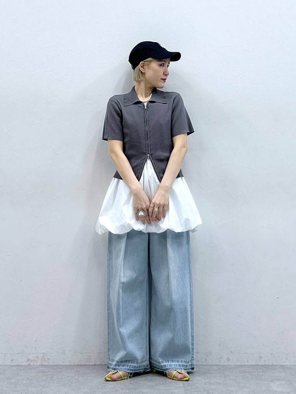 ブルー系のデニムパンツ、グレー系のニット/セーター、ホワイト系のワンピースを着用したレディースの夏コーディネートの2枚目の写真