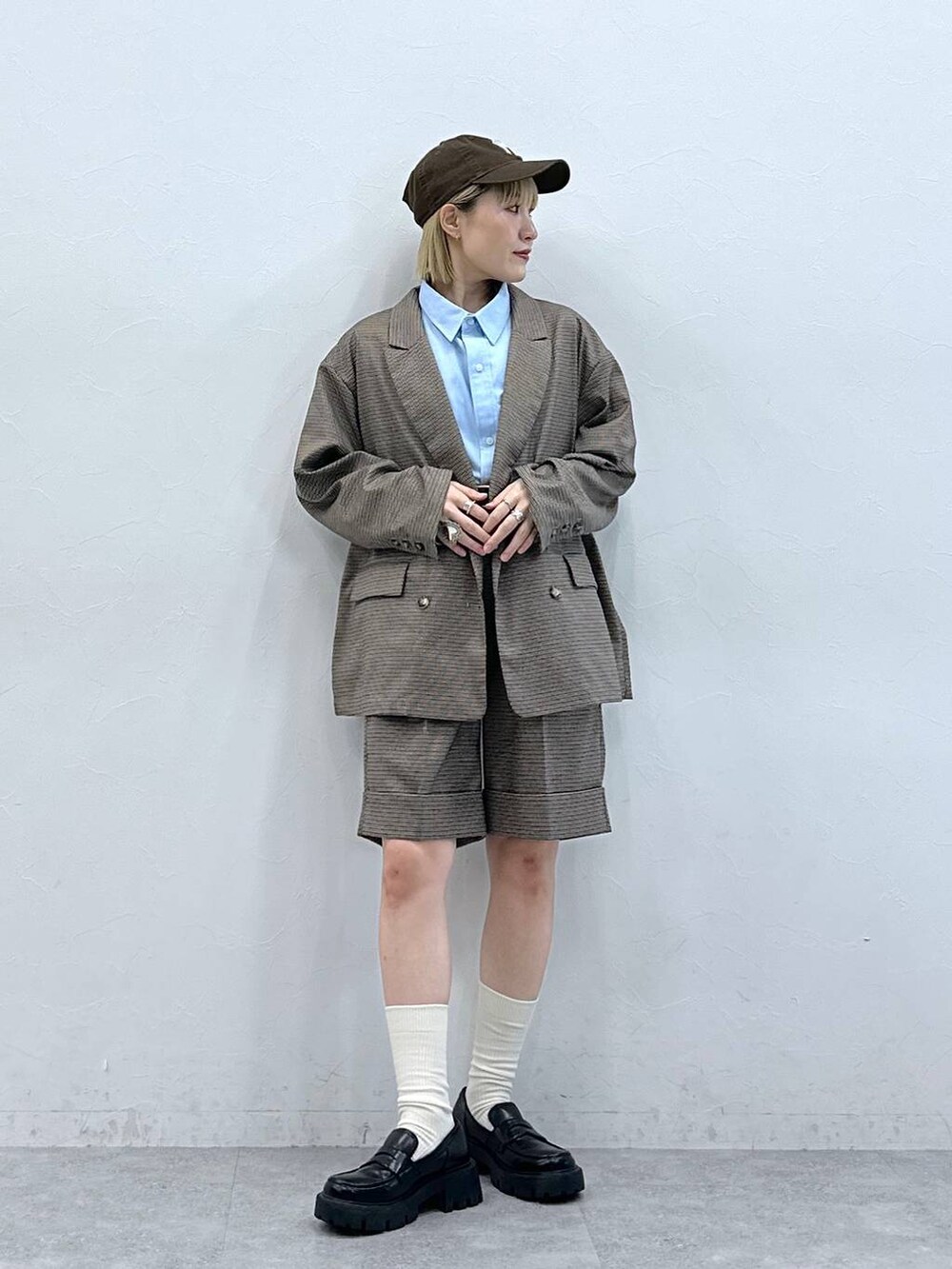 ブラック系のローファー、ブラウン系のスラックス、ブラウン系のテーラードジャケットを着用したレディースの夏コーディネートの3枚目の写真