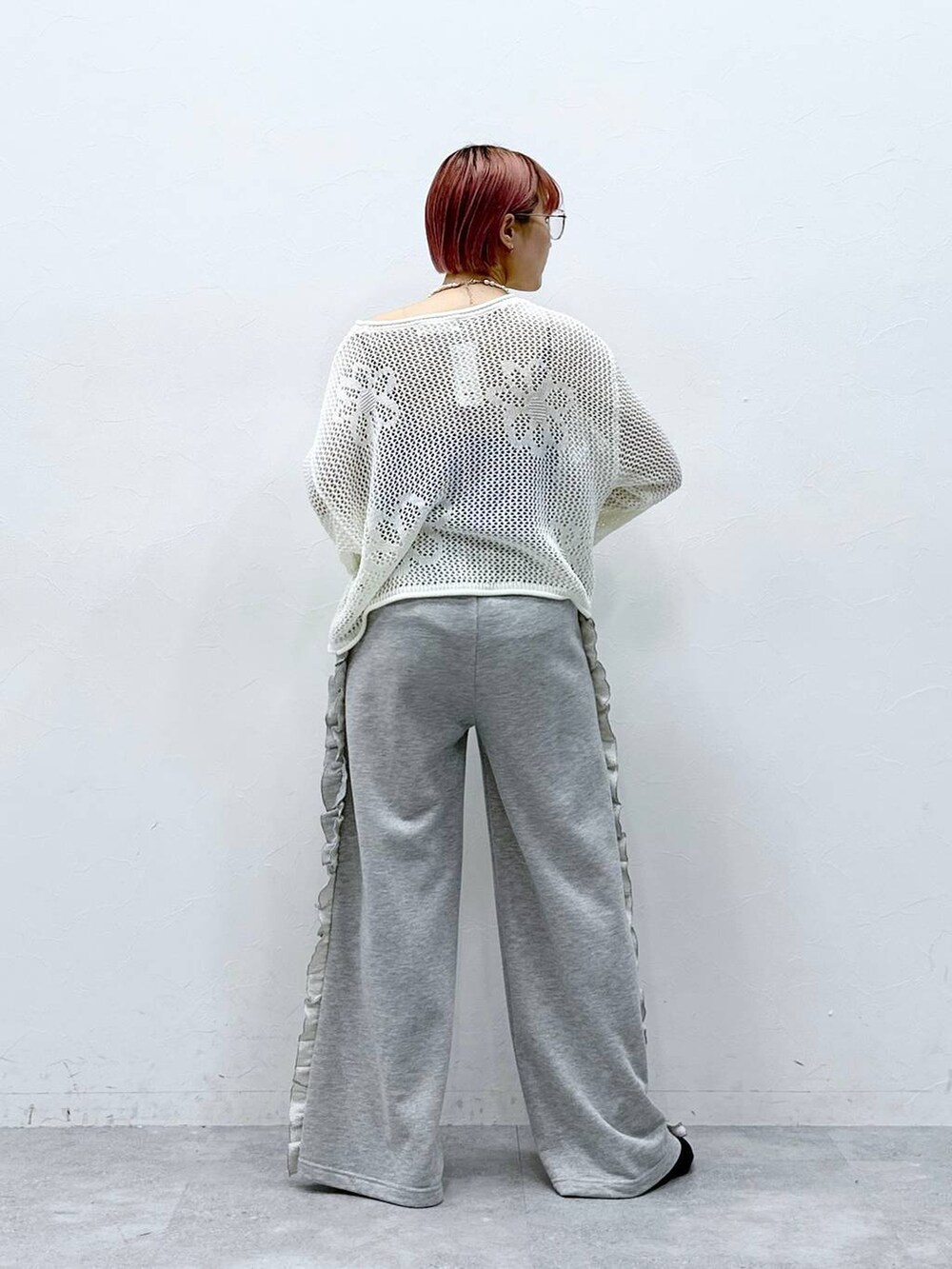 グレー系のスウェットパンツ、ホワイト系のニット/セーター、ホワイト系のネックレスを着用したレディースの春コーディネートの5枚目の写真