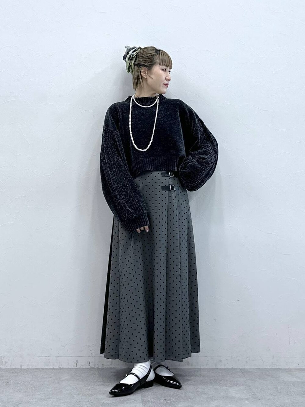 ブラック系のニット/セーター、ブラック系のパンプス、グレー系のスカートを着用したレディースの冬コーディネートの3枚目の写真