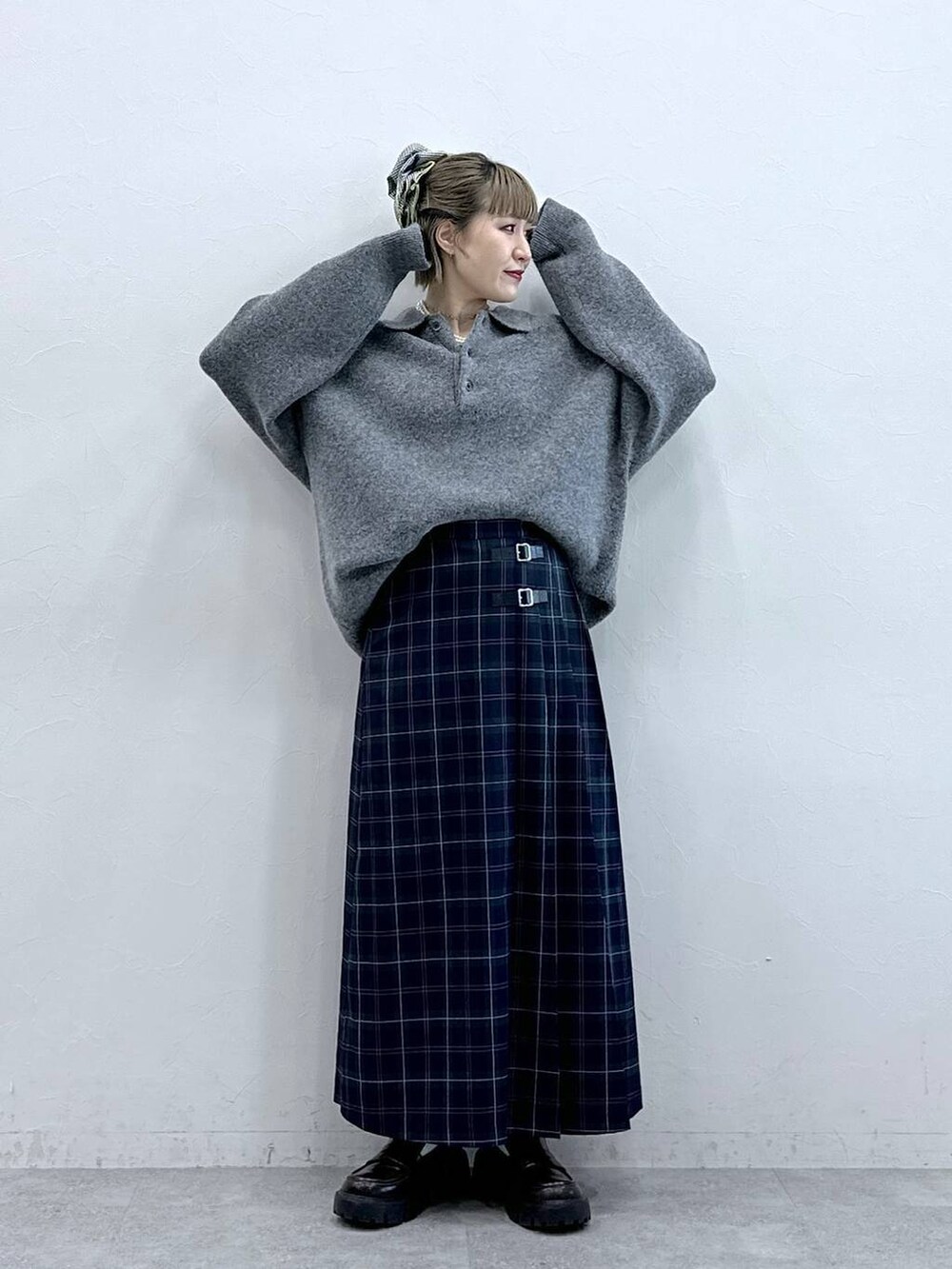 ブラック系のローファー、グリーン系のスカート、グレー系のポロシャツを着用したレディースの冬コーディネートの2枚目の写真