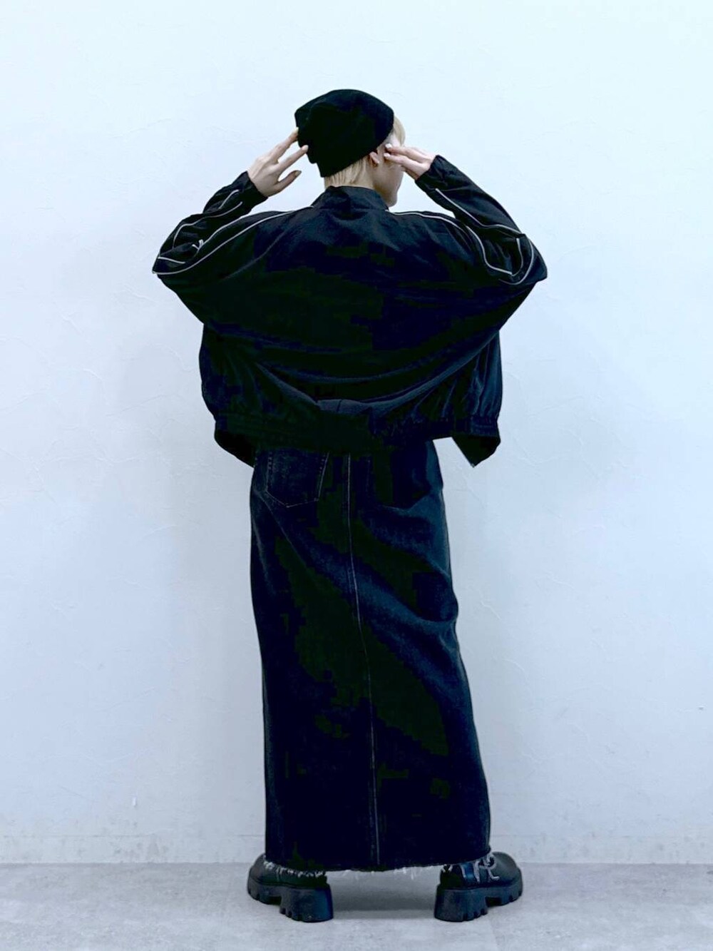 ブラック系のブーツ、ブラック系のデニムスカートを着用したレディースの冬コーディネートの4枚目の写真