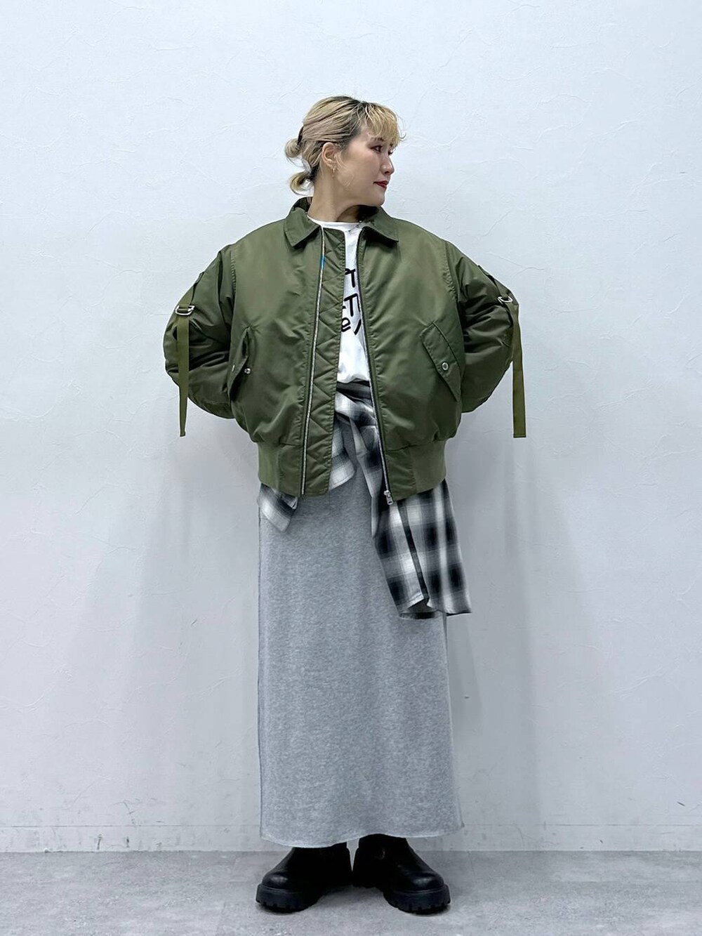 ブラック系のシャツ/ブラウス、ブラック系のブーツ、ホワイト系のTシャツ/カットソーを着用したレディースの秋コーディネートの2枚目の写真