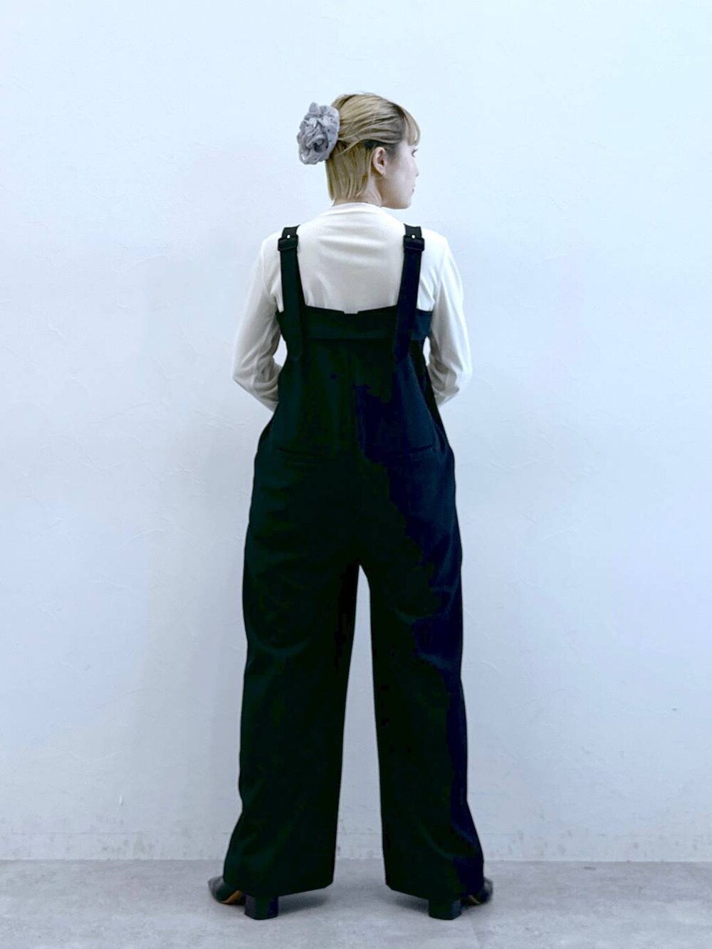 ブラック系のサロペット/オーバーオール、ホワイト系のTシャツ/カットソーを着用したレディースの冬コーディネートの4枚目の写真