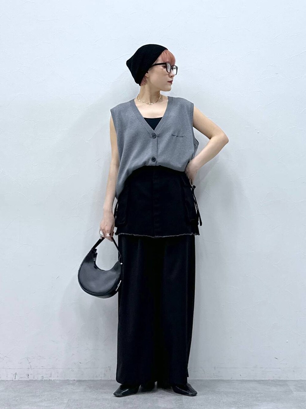 ブラック系のスラックス、ブラック系のスカート、グレー系のベストを着用したレディースの春コーディネートの4枚目の写真