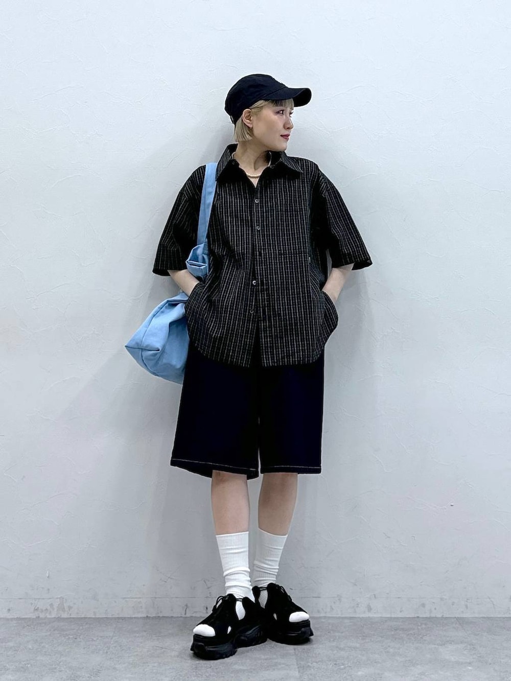 ブラック系のサンダル、ブルー系のデニムパンツ、ピンク系のトートバッグを着用したレディースの夏コーディネートの3枚目の写真