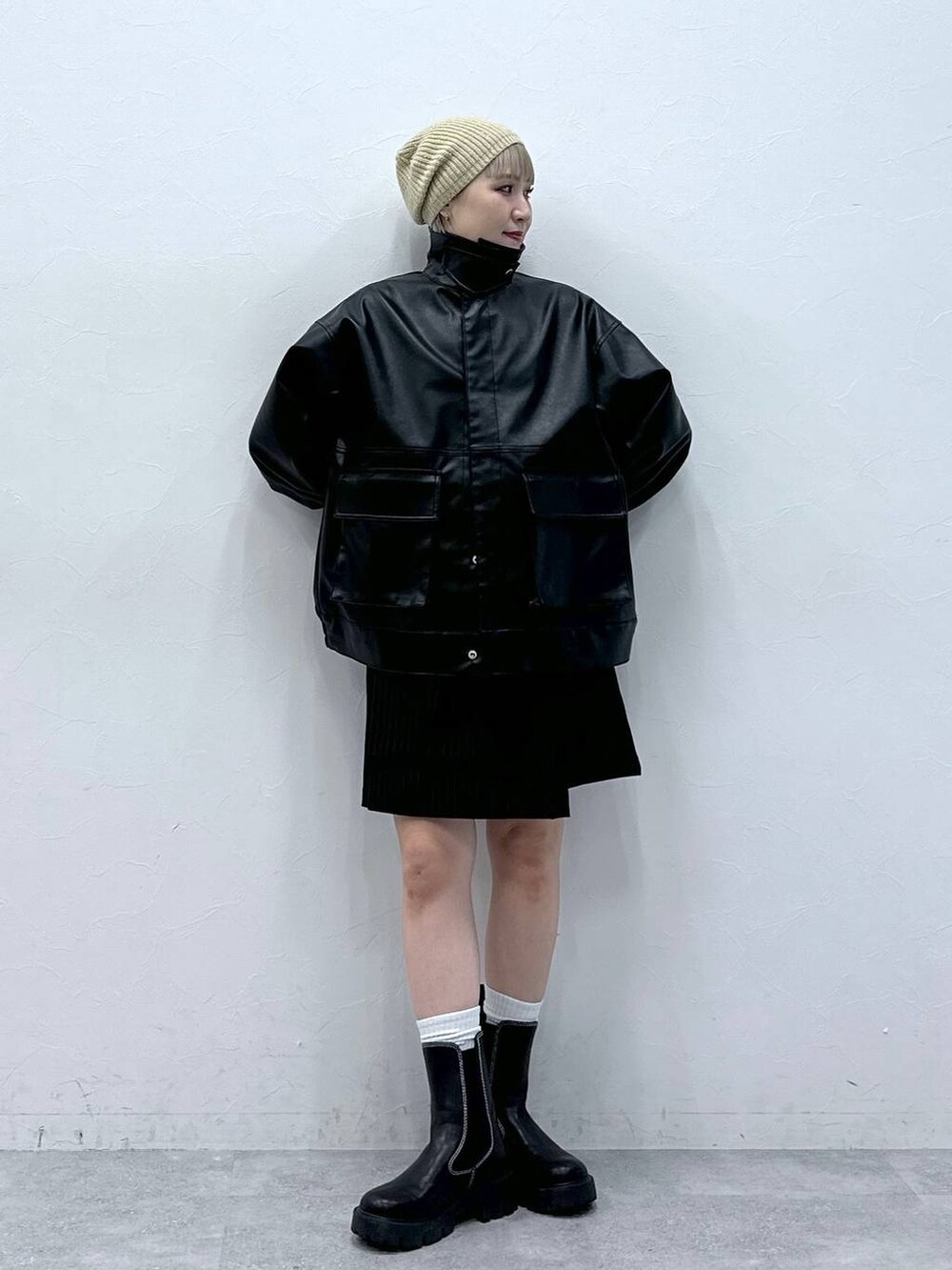 ブラック系のブーツ、ブラック系のスカート、ブラック系のブルゾンを着用したレディースの秋コーディネートの3枚目の写真