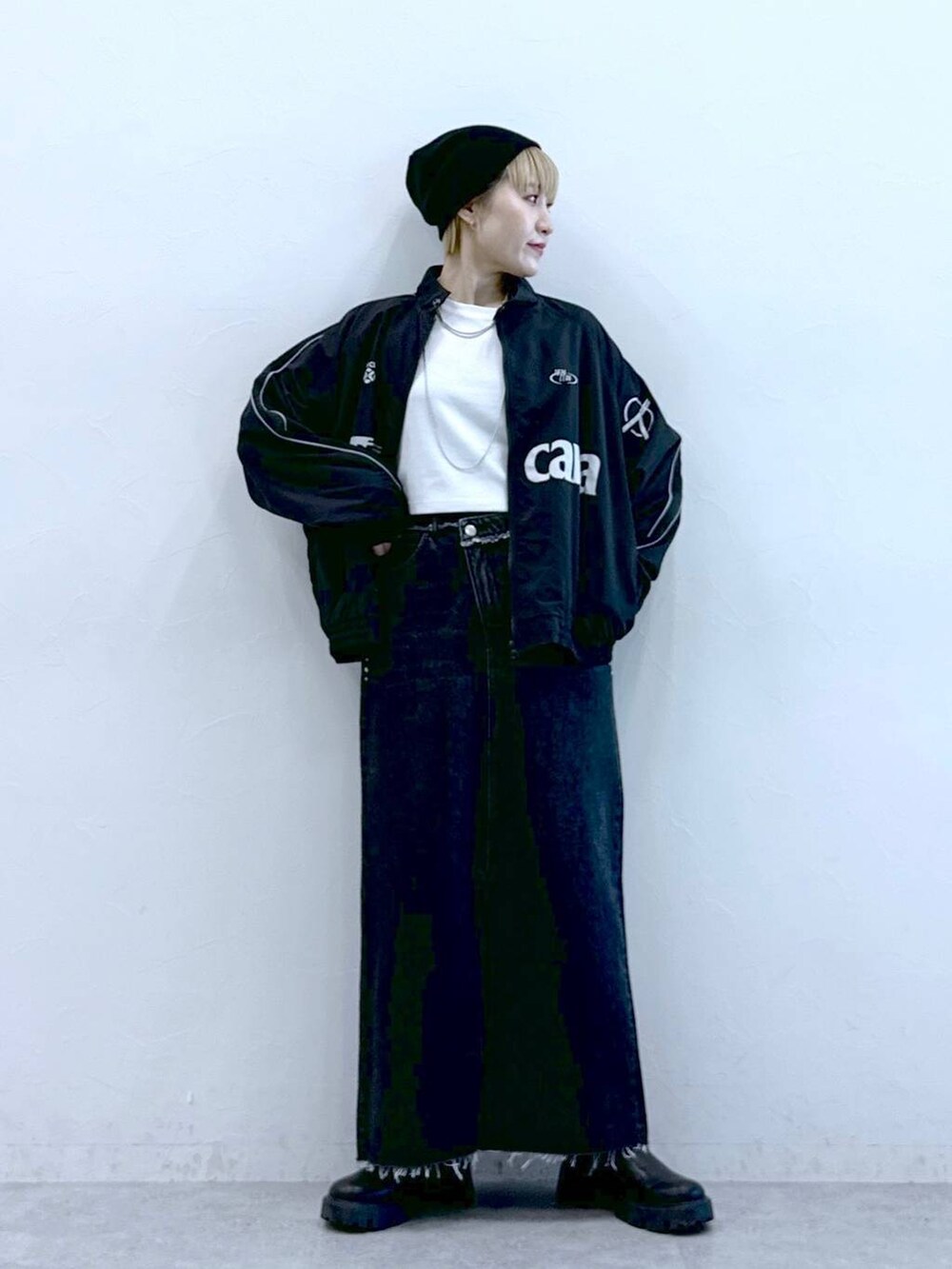 ブラック系のブーツ、ブラック系のデニムスカートを着用したレディースの冬コーディネートの5枚目の写真