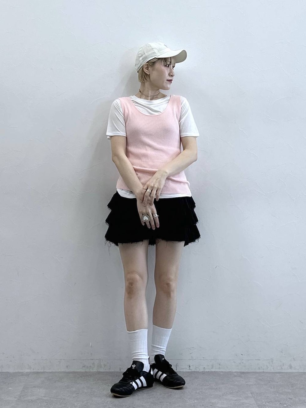 ブラック系のスニーカー、ピンク系のタンクトップ、ホワイト系のTシャツ/カットソーを着用したレディースの春コーディネートの3枚目の写真