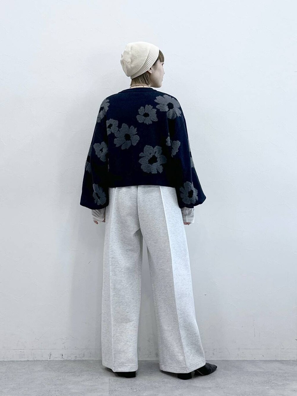 ホワイト系のスウェットパンツ、ブルー系のニット/セーター、ホワイト系のTシャツ/カットソーを着用したレディースの冬コーディネートの5枚目の写真