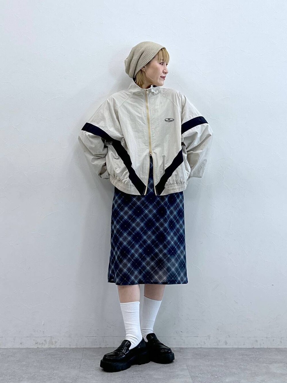 ブラック系のローファー、ブルー系のスカート、ホワイト系のブルゾンを着用したレディースの夏コーディネートの2枚目の写真