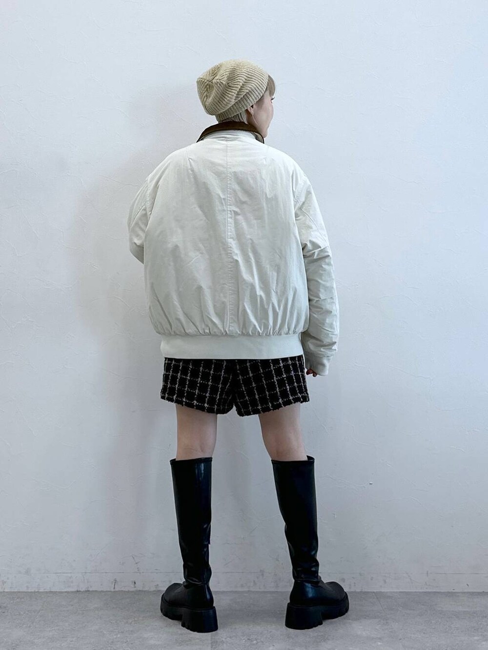 ブラック系のブーツ、ホワイト系のブルゾン、ブラウン系のその他パンツを着用したレディースの冬コーディネートの4枚目の写真