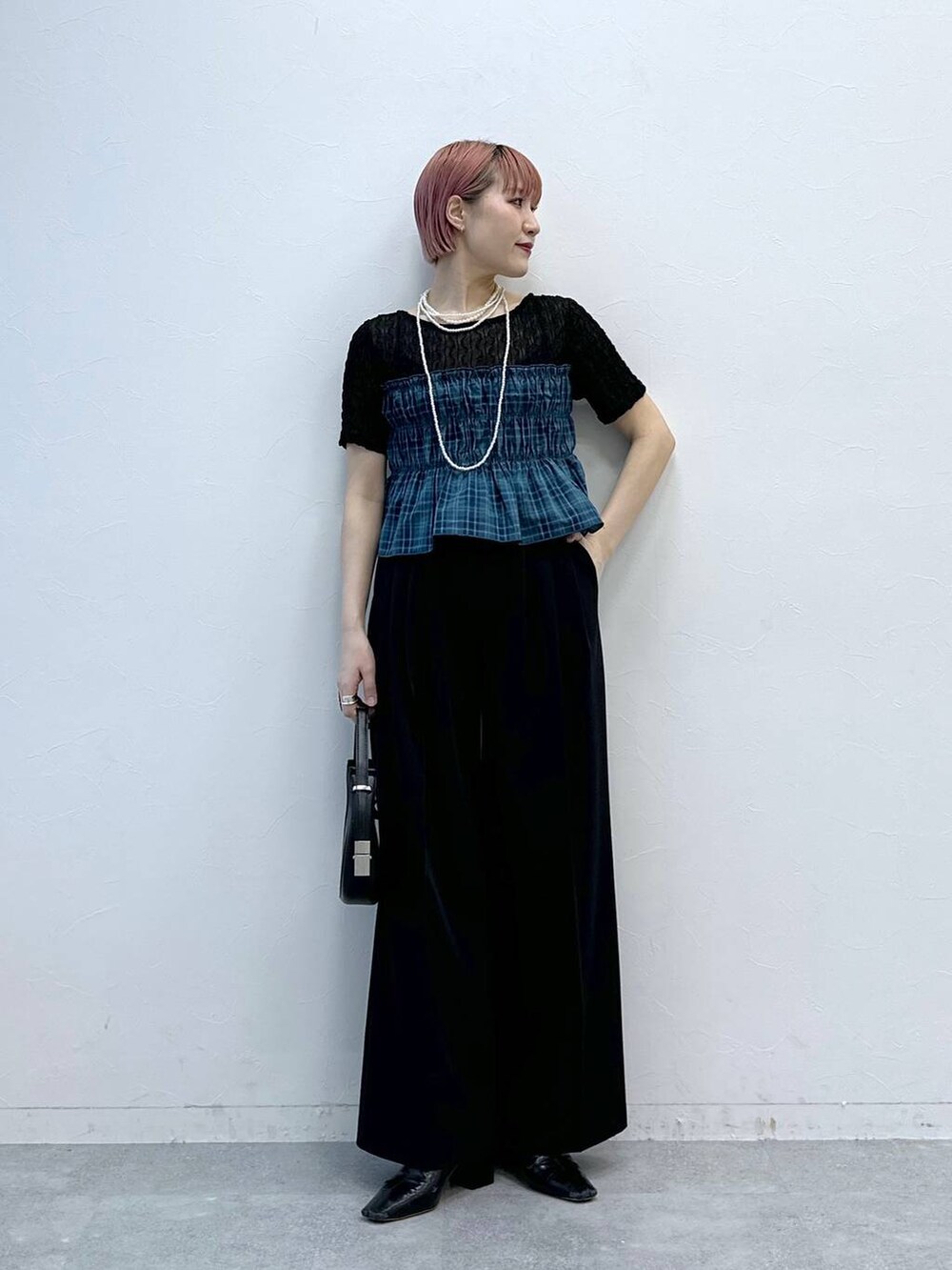 ブラック系のスラックス、ブラック系のTシャツ/カットソーを着用したレディースの春コーディネートの5枚目の写真