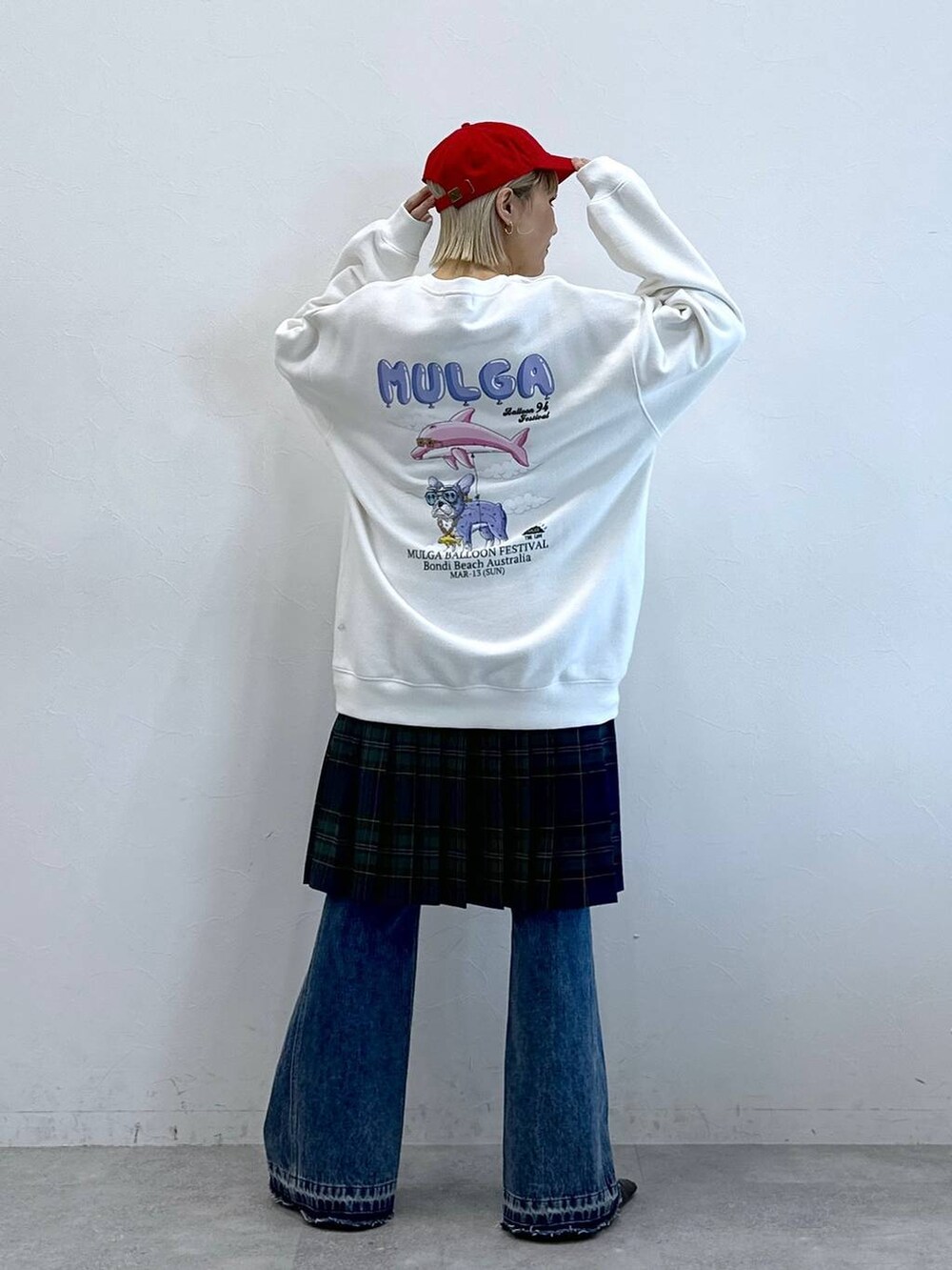 グリーン系のスカート、ブルー系のデニムパンツ、ホワイト系のスウェットを着用したレディースの秋コーディネートの3枚目の写真