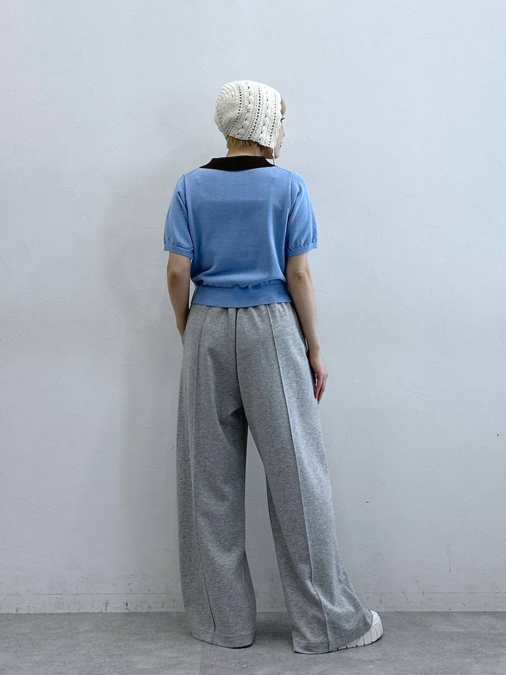 グレー系のスウェットパンツ、ブルー系のポロシャツ、ホワイト系のニットキャップ/ビーニーを着用したレディースの春コーディネートの5枚目の写真