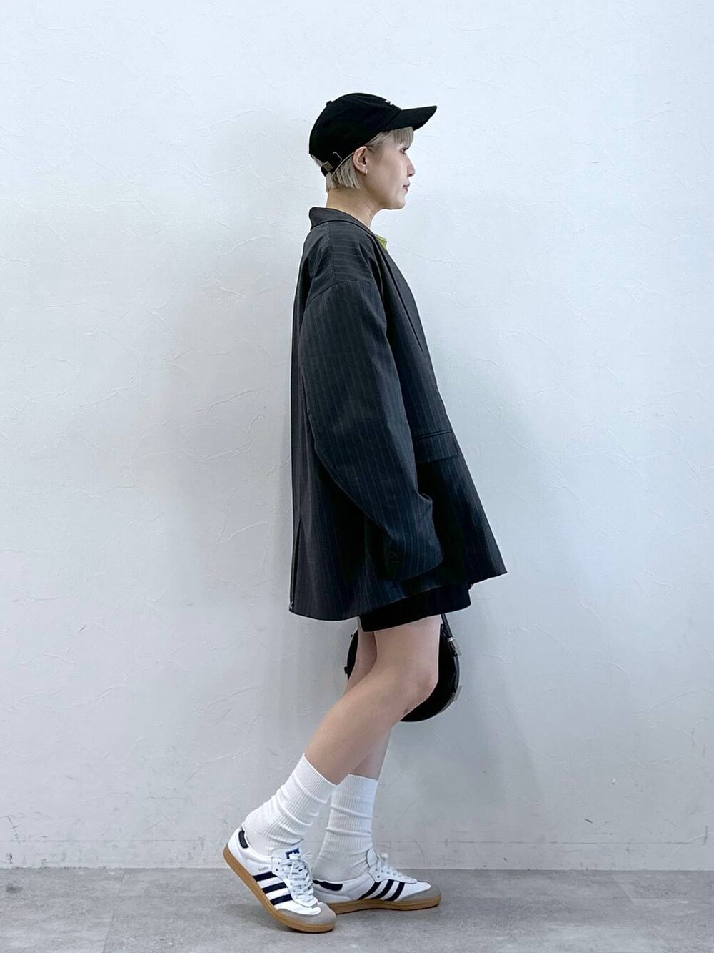 ブラック系のチノパンツ、グリーン系のTシャツ/カットソー、グレー系のテーラードジャケットを着用したレディースの冬コーディネートの4枚目の写真