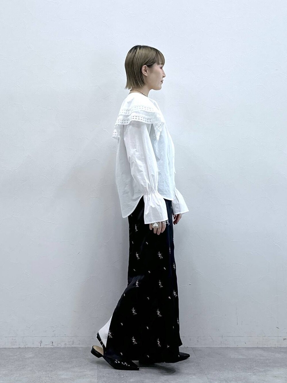 ホワイト系のシャツ/ブラウス、ブラック系のパンプス、ブラック系のスカートを着用したレディースの冬コーディネートの4枚目の写真