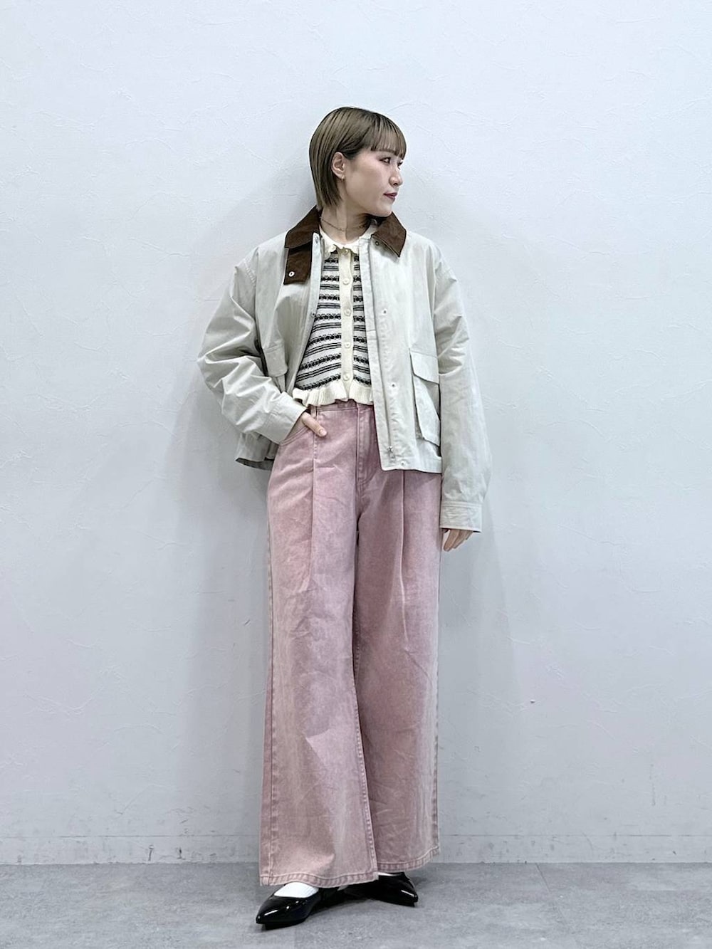 ブラック系のパンプス、ピンク系のデニムパンツ、ホワイト系のブルゾンを着用したレディースの冬コーディネートの3枚目の写真