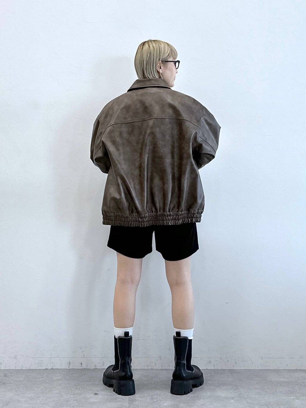 ブラック系のチノパンツ、ブラック系のブーツ、ブラウン系のブルゾンを着用したレディースの冬コーディネートの3枚目の写真