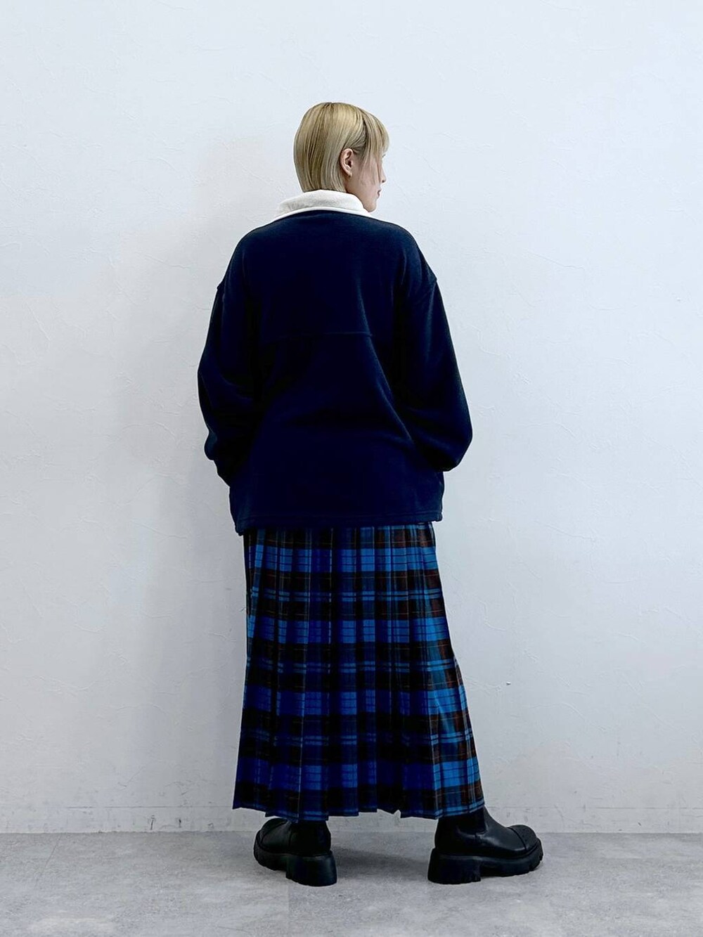 ブルー系のスウェット、ブラック系のブーツ、ブルー系のスカートを着用したレディースの秋コーディネートの7枚目の写真