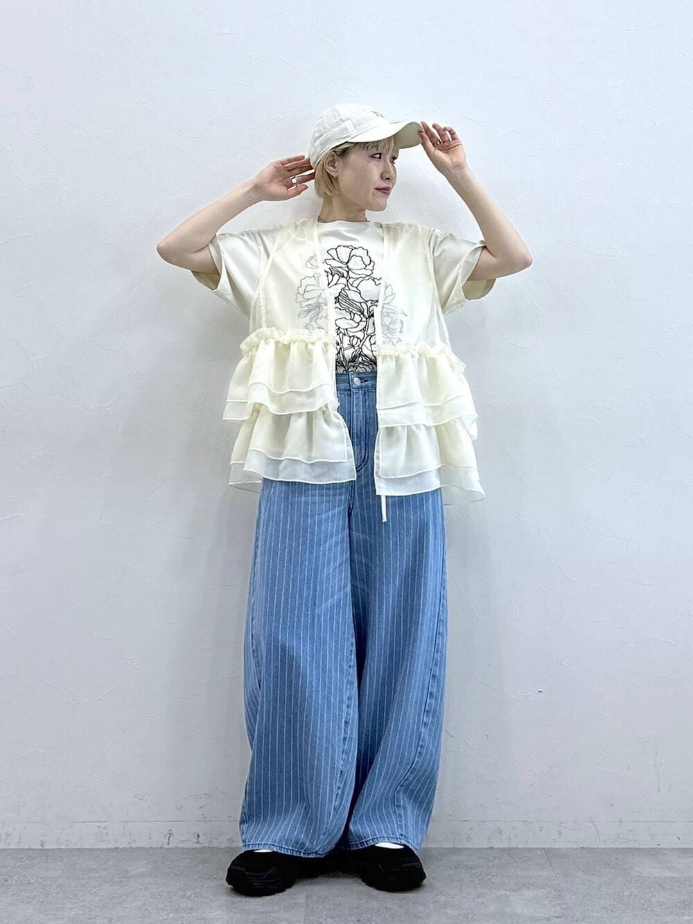ブラック系のサンダル、ホワイト系のTシャツ/カットソー、ホワイト系のベストを着用したレディースの春コーディネートの2枚目の写真