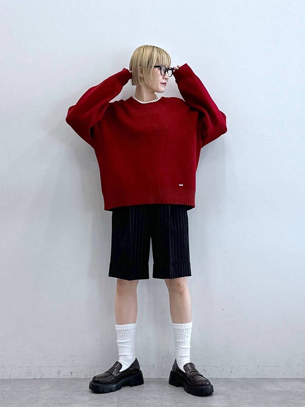 ブラック系のローファー、ブラック系のスラックス、レッド系のニット/セーターを着用したレディースの秋コーディネートの3枚目の写真