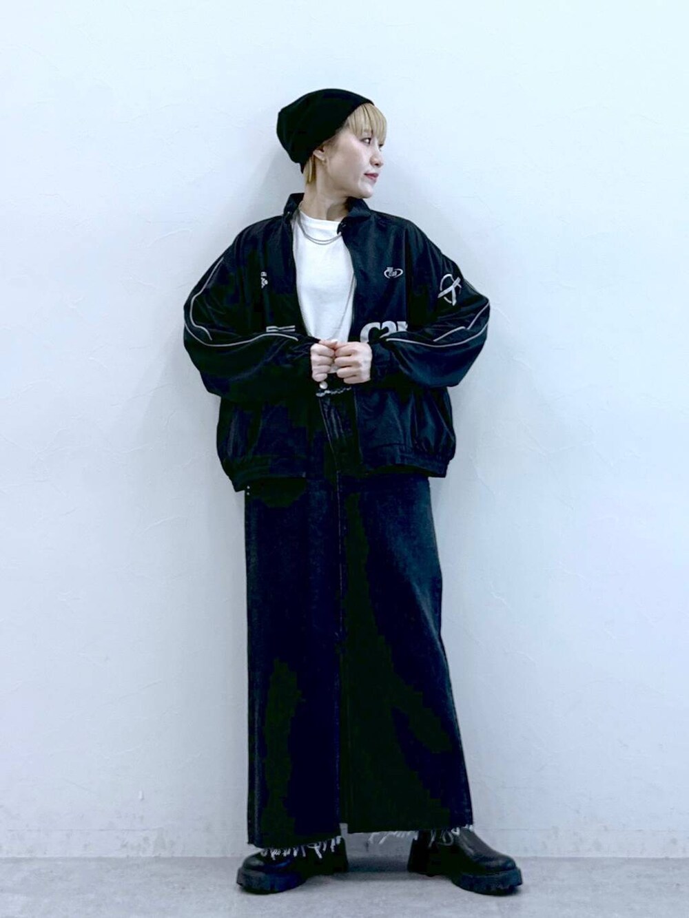 ブラック系のブーツ、ブラック系のデニムスカートを着用したレディースの冬コーディネートの2枚目の写真