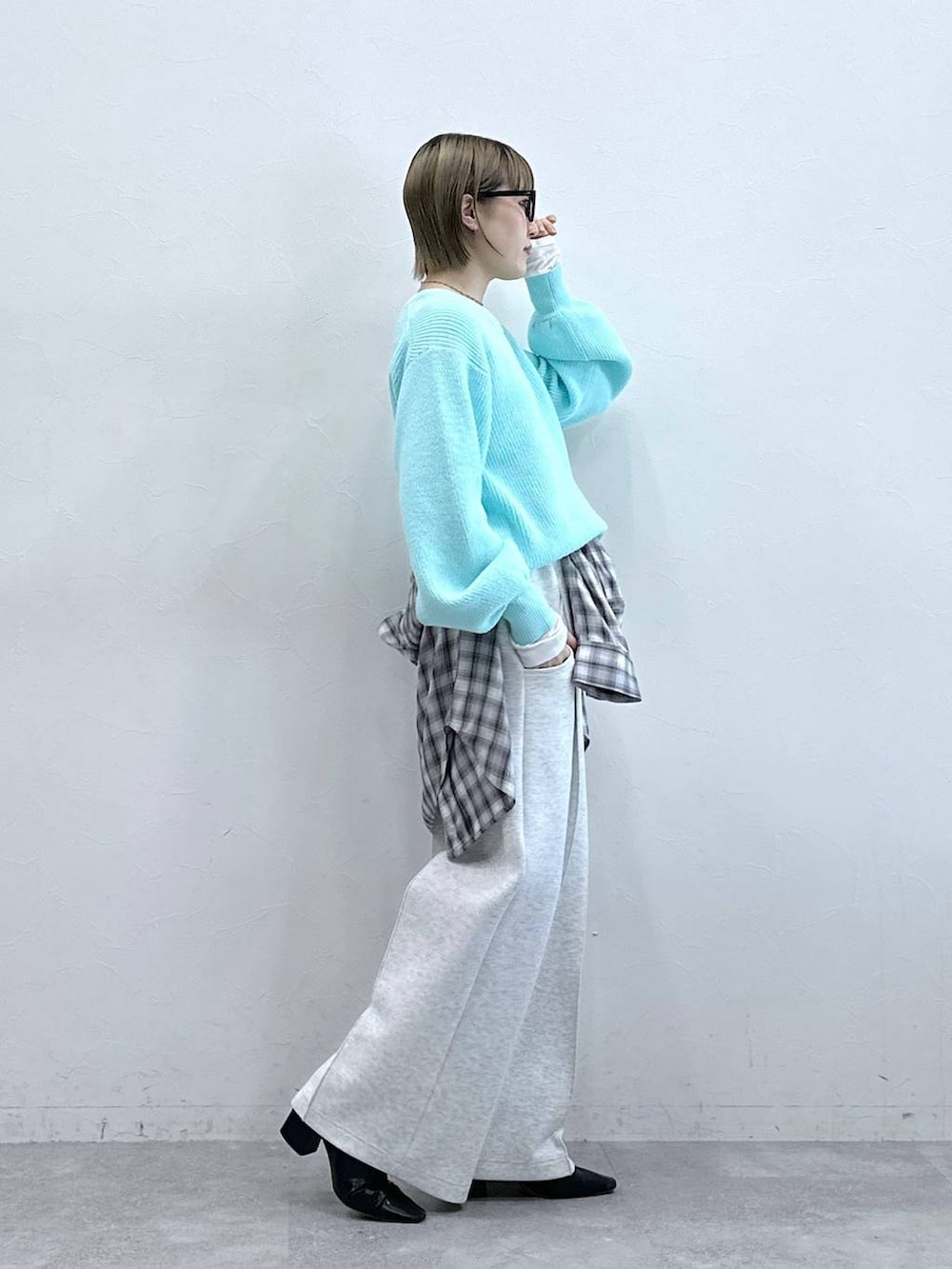 ホワイト系のスウェットパンツ、ブルー系のニット/セーター、ホワイト系のTシャツ/カットソーを着用したレディースの冬コーディネートの5枚目の写真