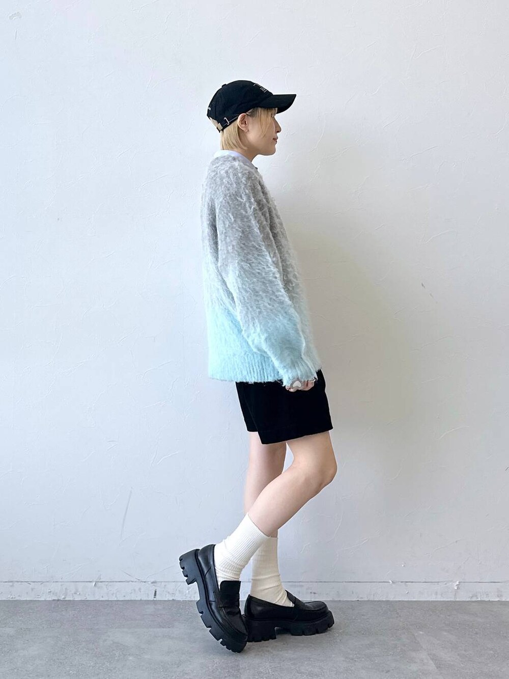 ブラック系のローファー、グレー系のニット/セーター、ブルー系のシャツ/ブラウスを着用したレディースの秋コーディネートの5枚目の写真