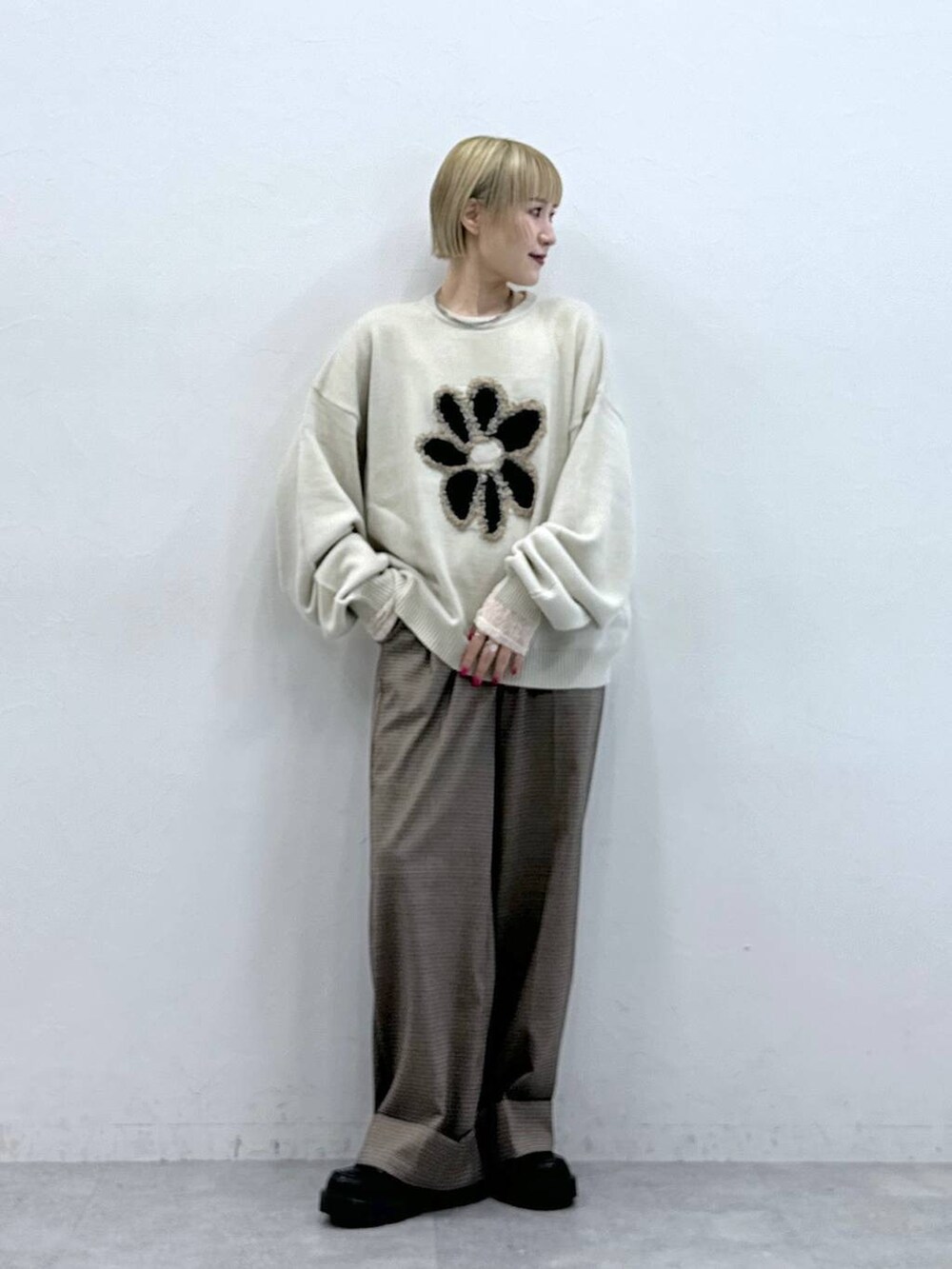 ホワイト系のニット/セーター、ブラック系のローファー、ブラウン系のスラックスを着用したレディースの秋コーディネートの2枚目の写真