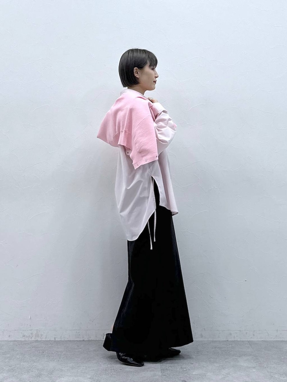 ピンク系のカーディガン/ボレロ、ブラック系のスカート、ピンク系のシャツ/ブラウスを着用したレディースの春コーディネートの6枚目の写真