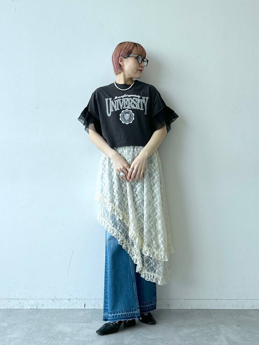 ブルー系のデニムパンツ、ホワイト系のスカート、ブラック系のTシャツ/カットソーを着用したレディースの春コーディネートの2枚目の写真