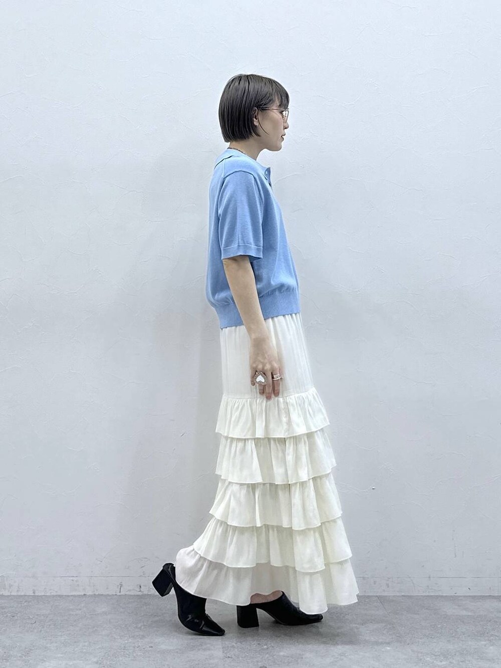 ブルー系のポロシャツ、ホワイト系のスカートを着用したレディースの春コーディネートの6枚目の写真