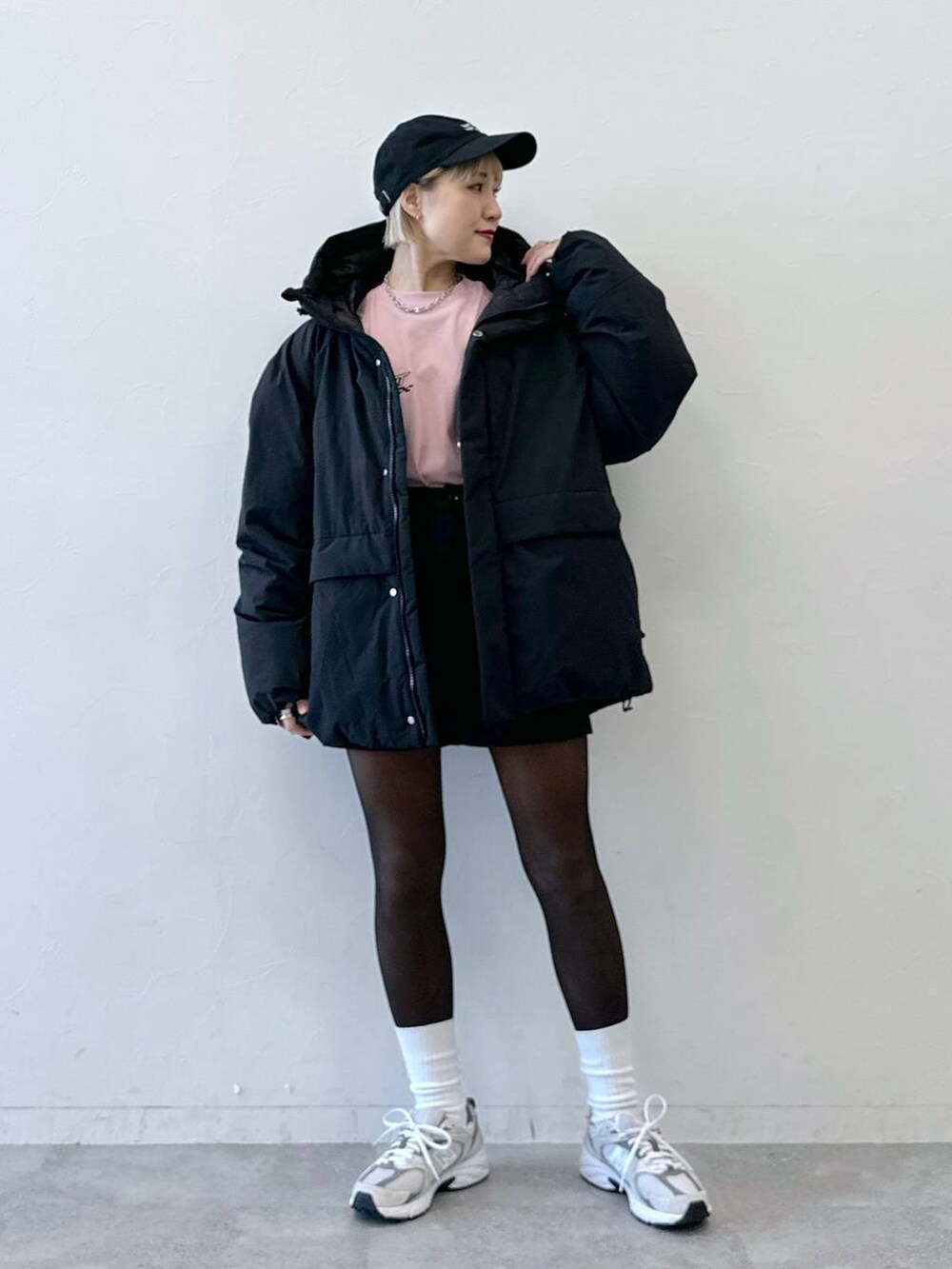 ブラック系のダウンジャケット/コート、ブラック系のその他パンツ、ピンク系のTシャツ/カットソーを着用したレディースの冬コーディネートの2枚目の写真