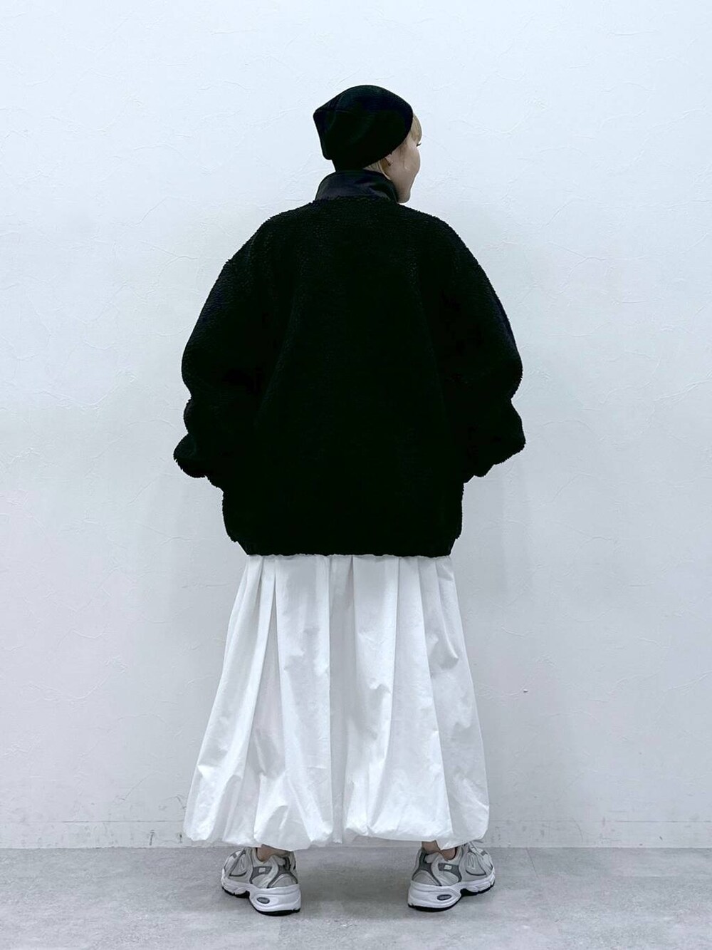 ブラック系のブルゾン、ホワイト系のスカートを着用したレディースの冬コーディネートの4枚目の写真