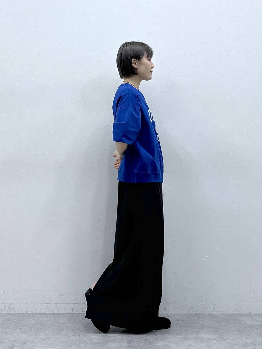 ブルー系のTシャツ/カットソー、ブラック系のモカシン/デッキシューズ、ブラック系のスカートを着用したレディースの春コーディネートの4枚目の写真