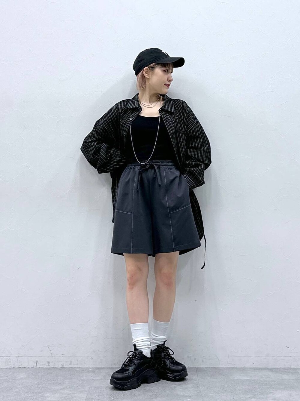 ブラック系のスニーカー、ブルー系のスラックス、ブラック系のシャツ/ブラウスを着用したレディースの春コーディネートの6枚目の写真