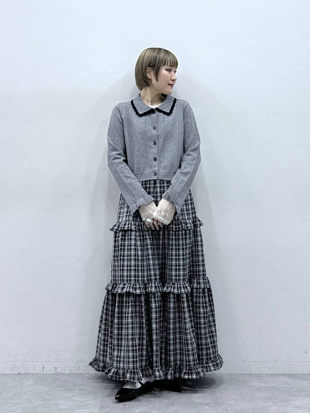 ホワイト系のTシャツ/カットソー、ブラック系のパンプス、グレー系のカーディガン/ボレロを着用したレディースの冬コーディネートの4枚目の写真