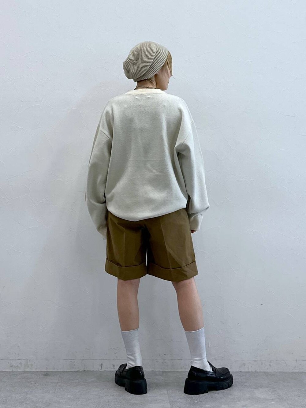 ホワイト系のニット/セーター、ブラック系のローファー、ブラウン系のチノパンツを着用したレディースの秋コーディネートの6枚目の写真