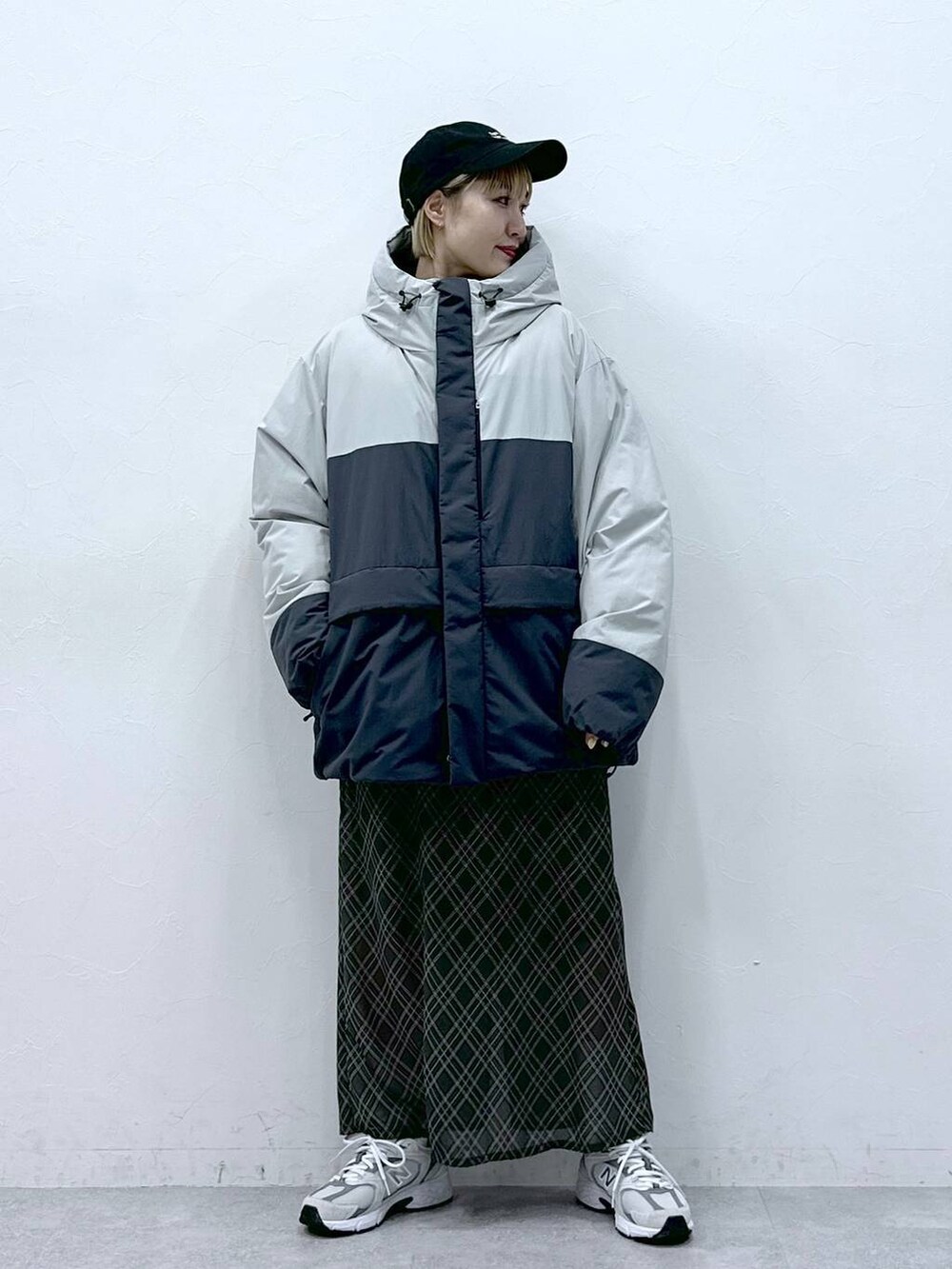 グレー系のダウンジャケット/コート、ブラック系のキャップを着用したレディースの冬コーディネートの2枚目の写真