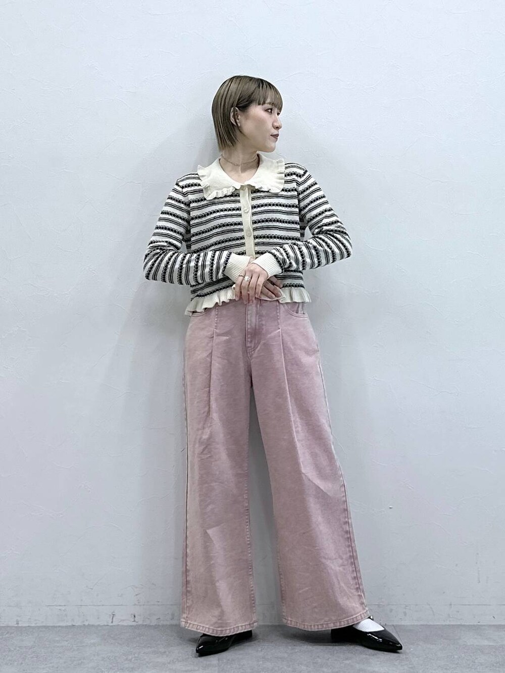 ブラック系のパンプス、ピンク系のデニムパンツ、ホワイト系のカーディガン/ボレロを着用したレディースの冬コーディネートの3枚目の写真