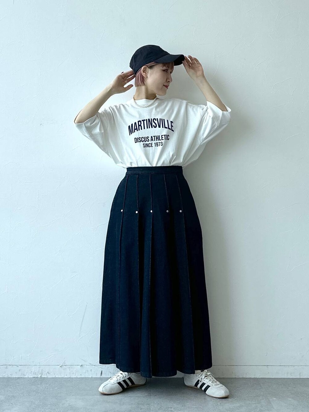 ホワイト系のTシャツ/カットソー、ホワイト系のスニーカー、ブルー系のデニムスカートを着用したレディースの春コーディネートの2枚目の写真