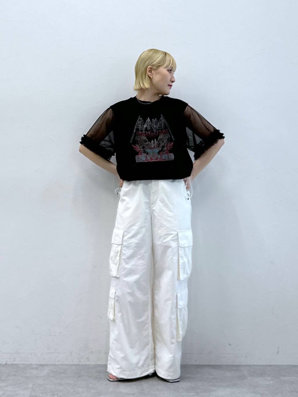 シルバー系のサンダル、ホワイト系のカーゴパンツ、ブラック系のTシャツ/カットソーを着用したレディースの夏コーディネートの3枚目の写真