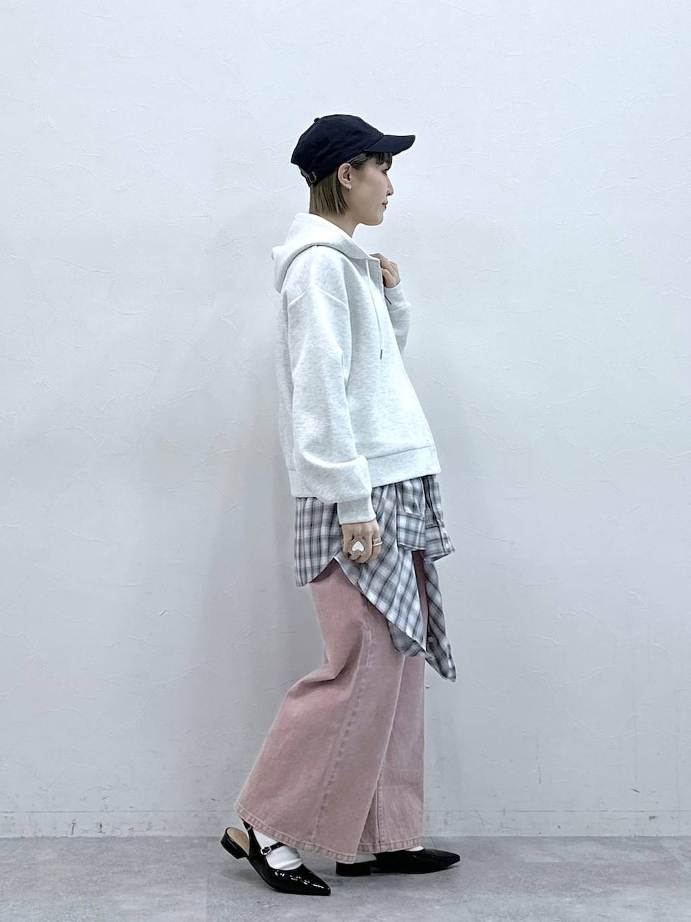 ブラック系のパンプス、ホワイト系のパーカー、ピンク系のデニムパンツを着用したレディースの冬コーディネートの4枚目の写真