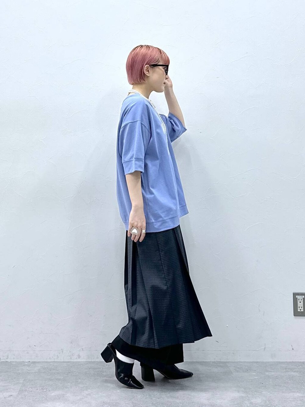 ブラック系のスラックス、ブルー系のTシャツ/カットソー、グレー系のスカートを着用したレディースの春コーディネートの5枚目の写真