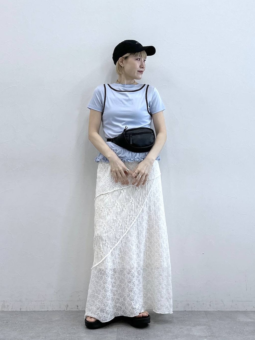 ブラック系のボディバッグ/ウエストポーチ、ブルー系のTシャツ/カットソー、ホワイト系のスカートを着用したレディースの春コーディネートの2枚目の写真